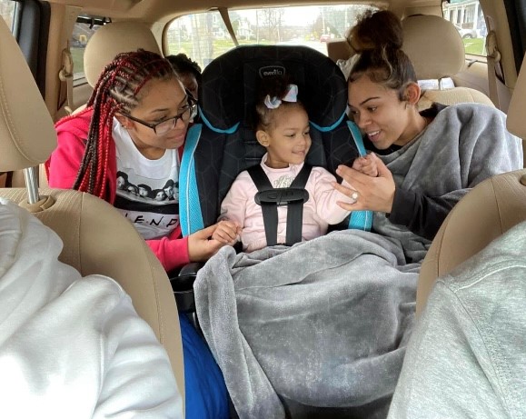 two teenage girls and toddler girl in car