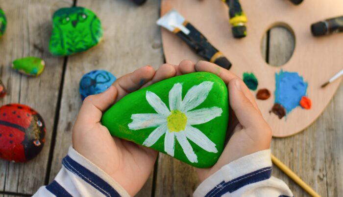 child hands holding painted rock