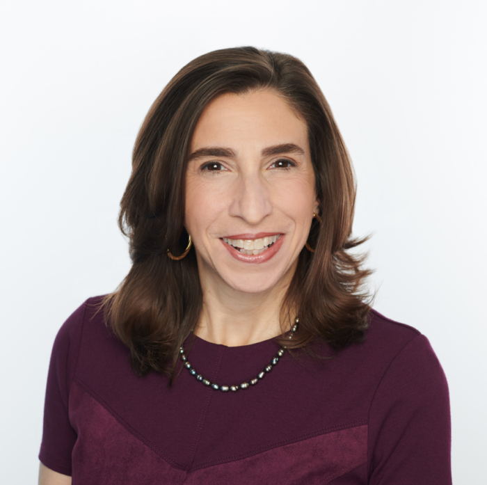 woman with brown hair, maroon shirt, and necklace