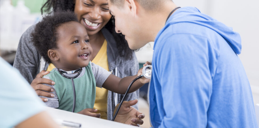 male medical professional with woman and toddler hold a stethoscope