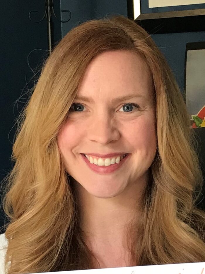 woman with strawberry blonde hair smiling at the camera