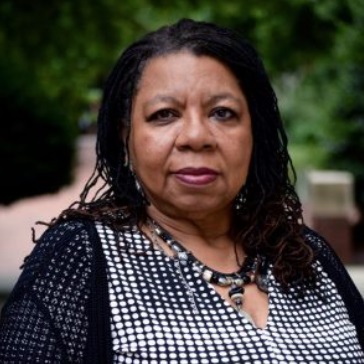 Black woman with long dark hair wearing a black and white shirt