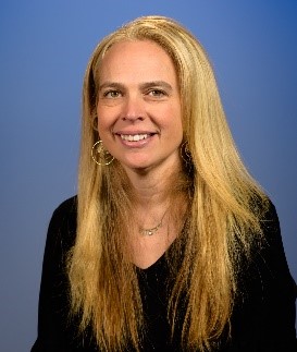 woman with long blonde hair and black shirt smiling at camera