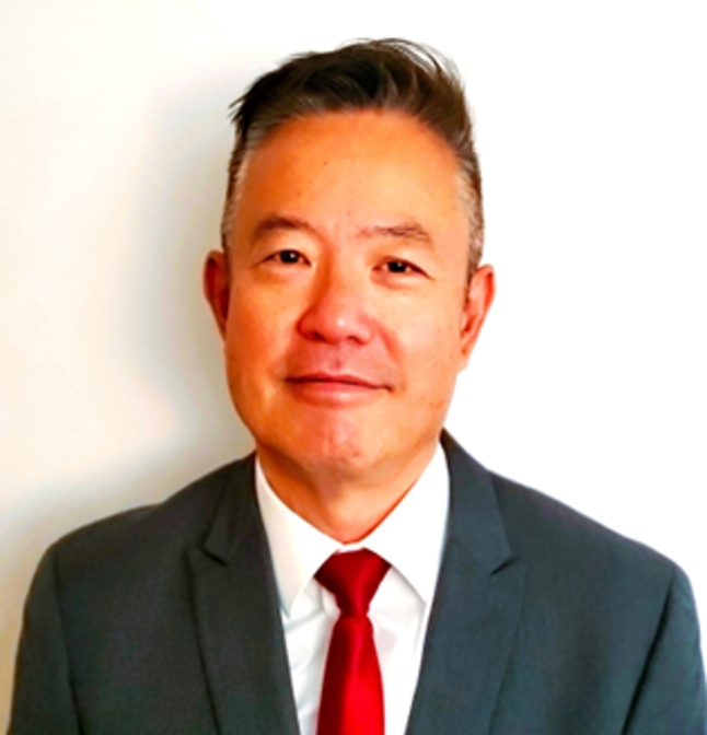 man in suit with red tie smiling at camera