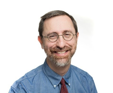 white man with glasses smiling at camera