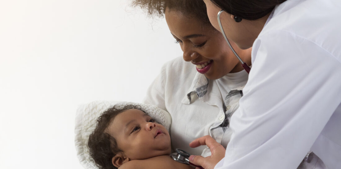 health care provider holding stethoscope to baby being held by woman