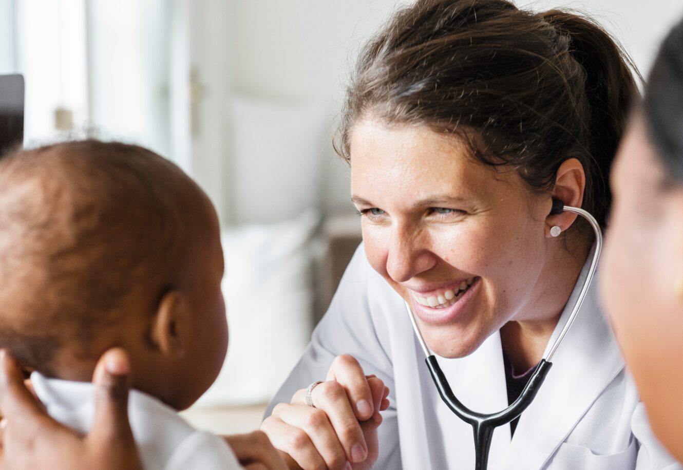 mother holding baby and a doctor with a stethoscope