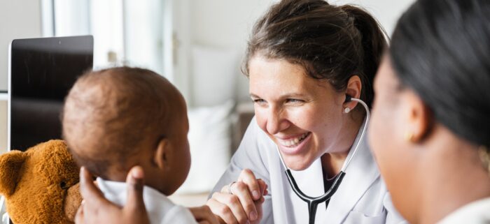mother holding baby and a doctor with a stethoscope