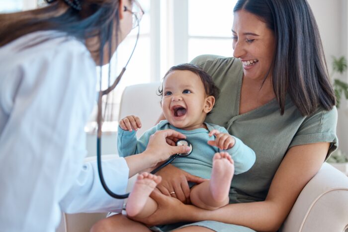 mother holding baby and a doctor with a stethoscope