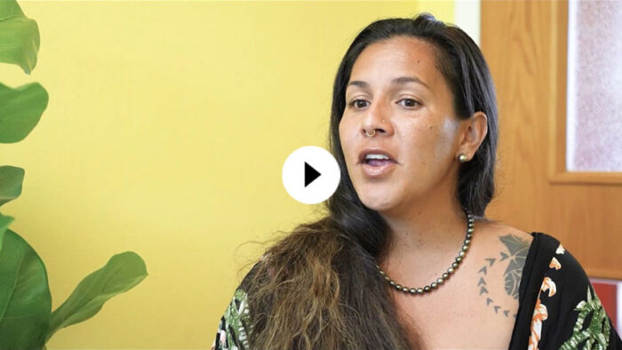 Woman with long dark hair talking to a camera